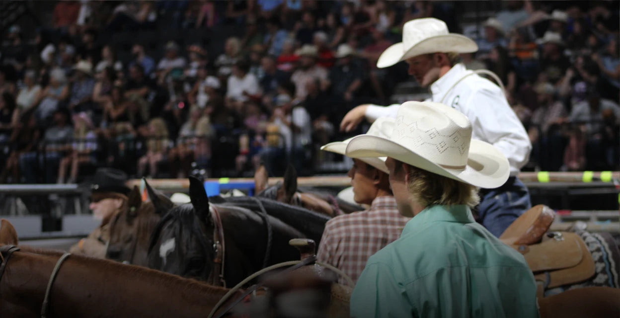 Men wearing cowboy hats at a rodeo